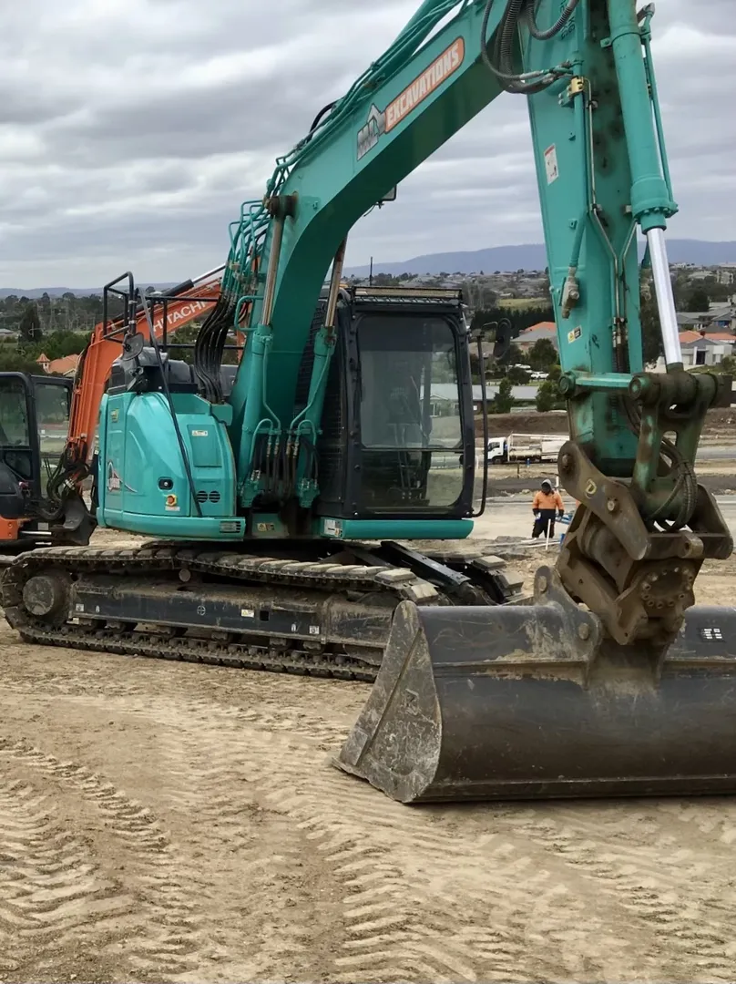Teal excavator working at a construction site
