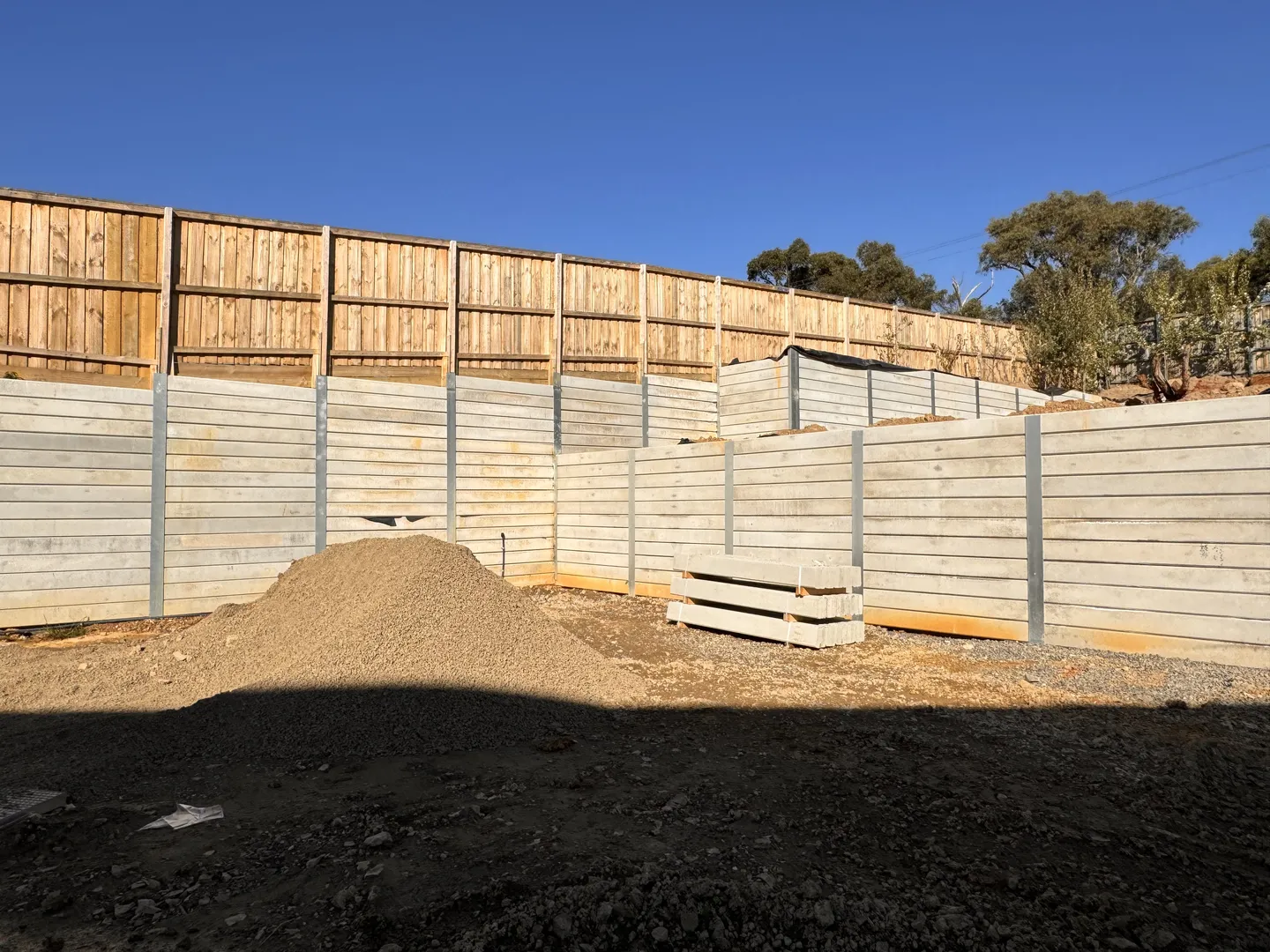 Construction site with concrete and wooden retaining walls.