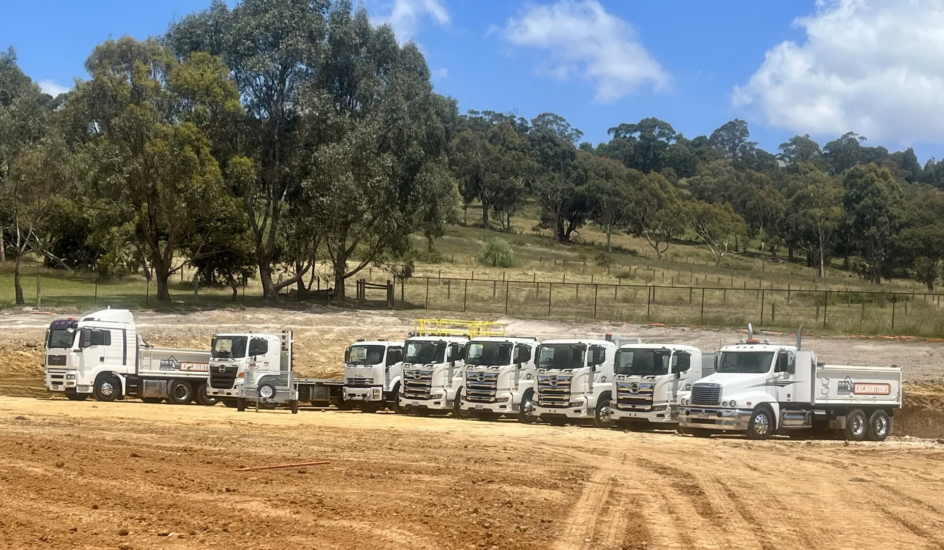 Row of trucks at construction site.