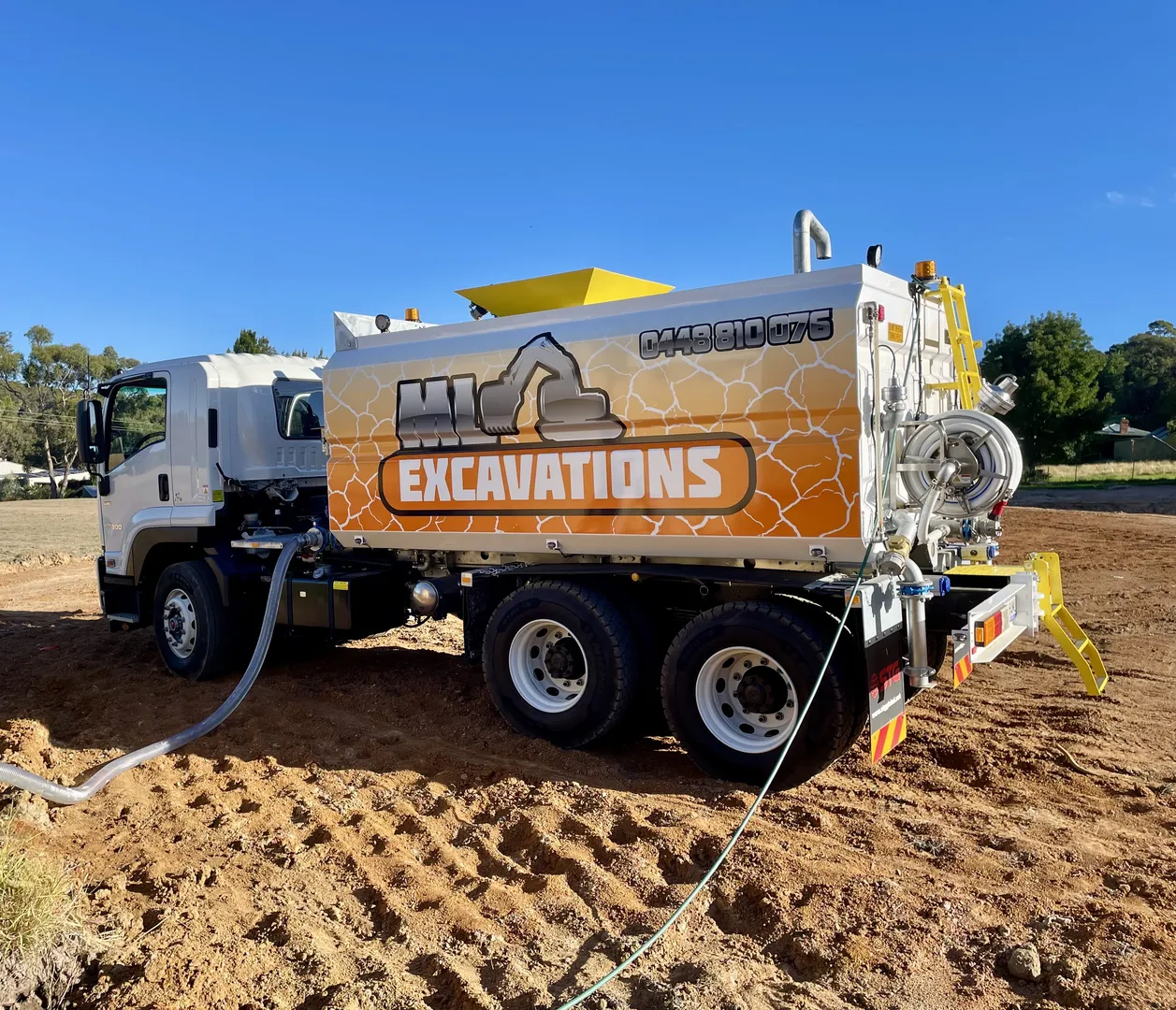 Excavation truck on construction site with clear sky background.