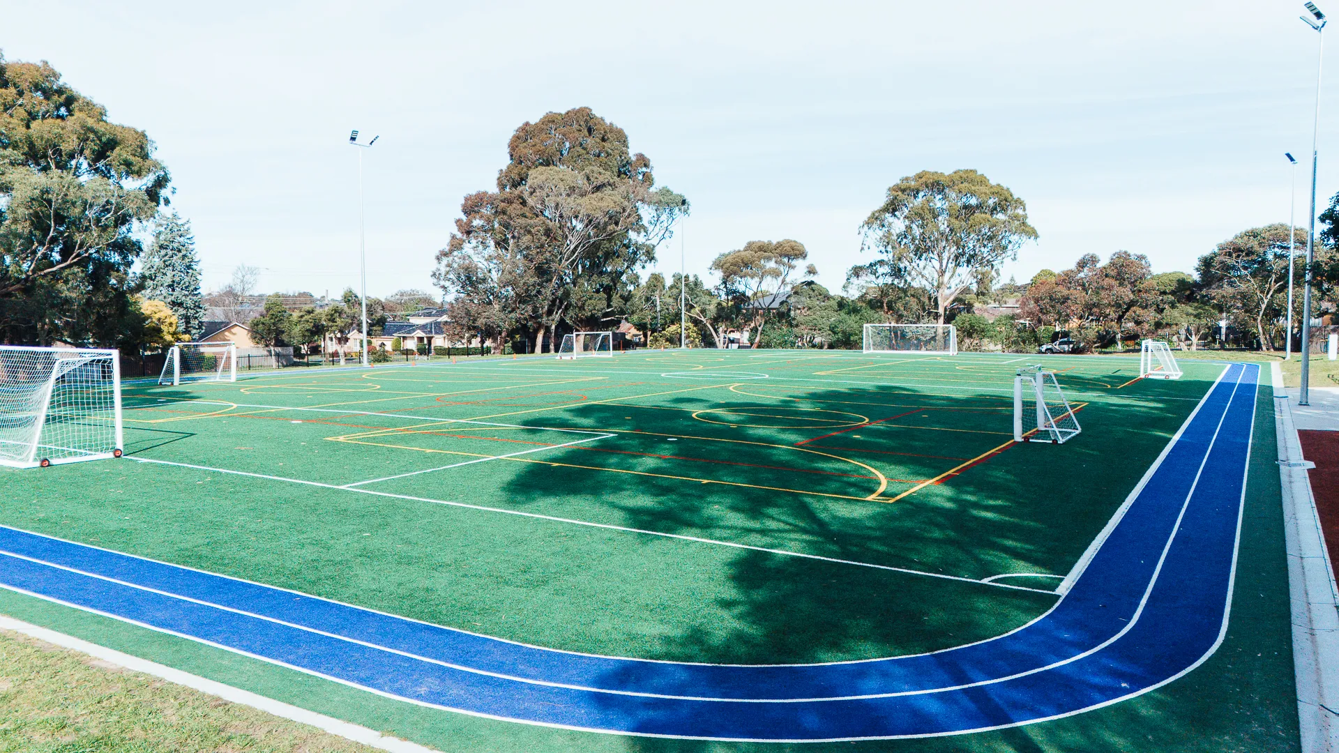 Outdoor soccer field with blue running track.