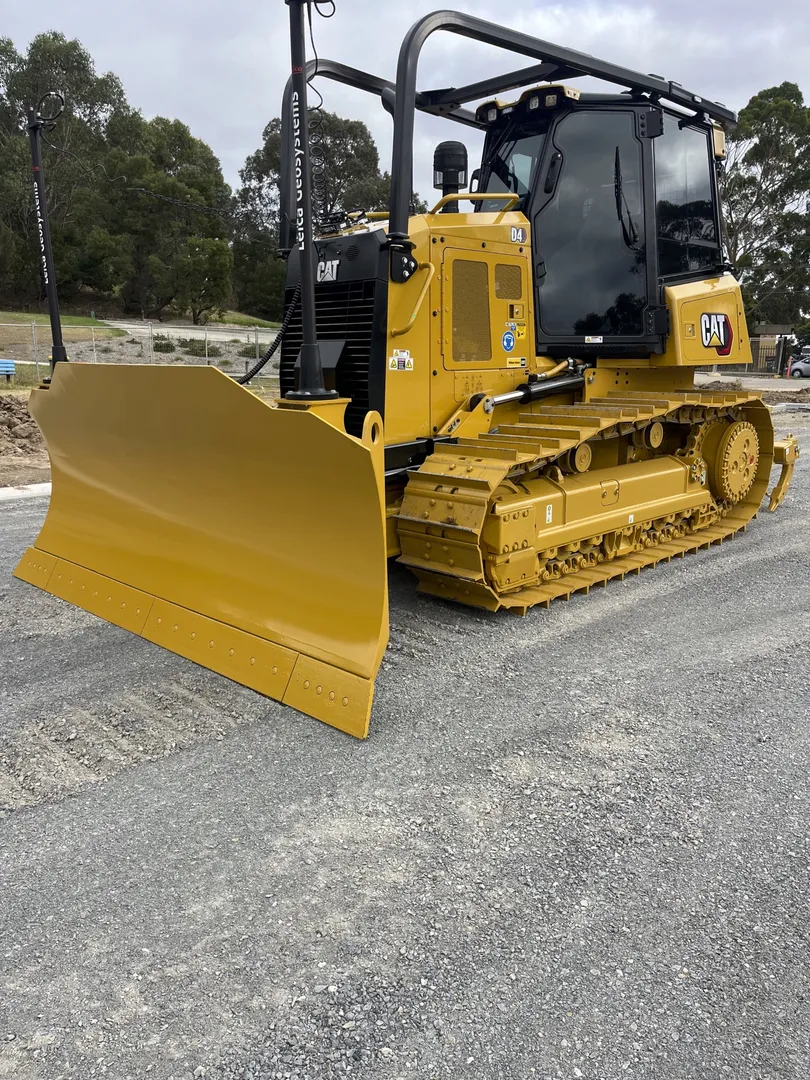 Yellow bulldozer on gravel road at construction site.